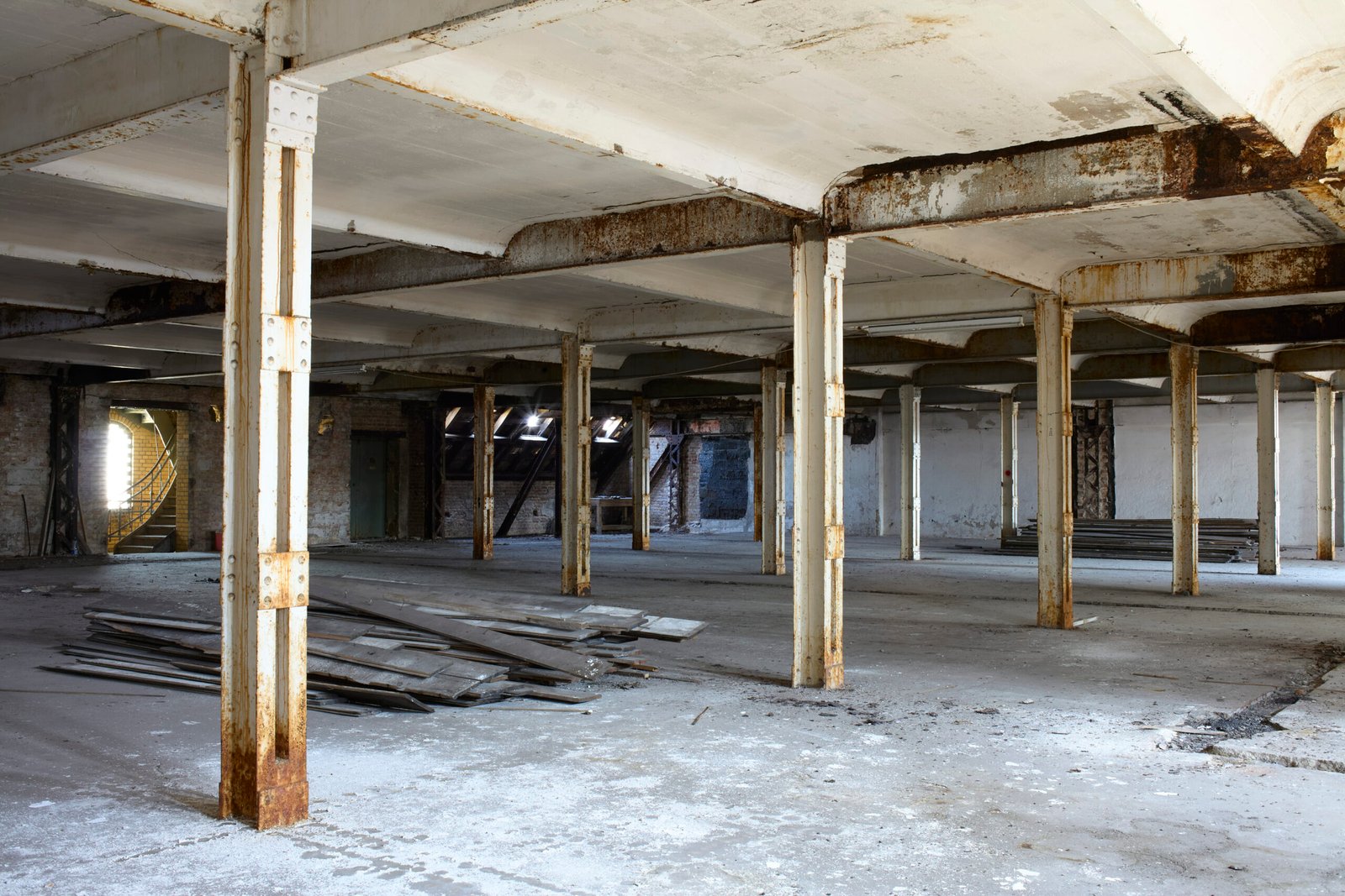 Abandoned industrial building interior with columns and scattered debris, Berlin, Germany
